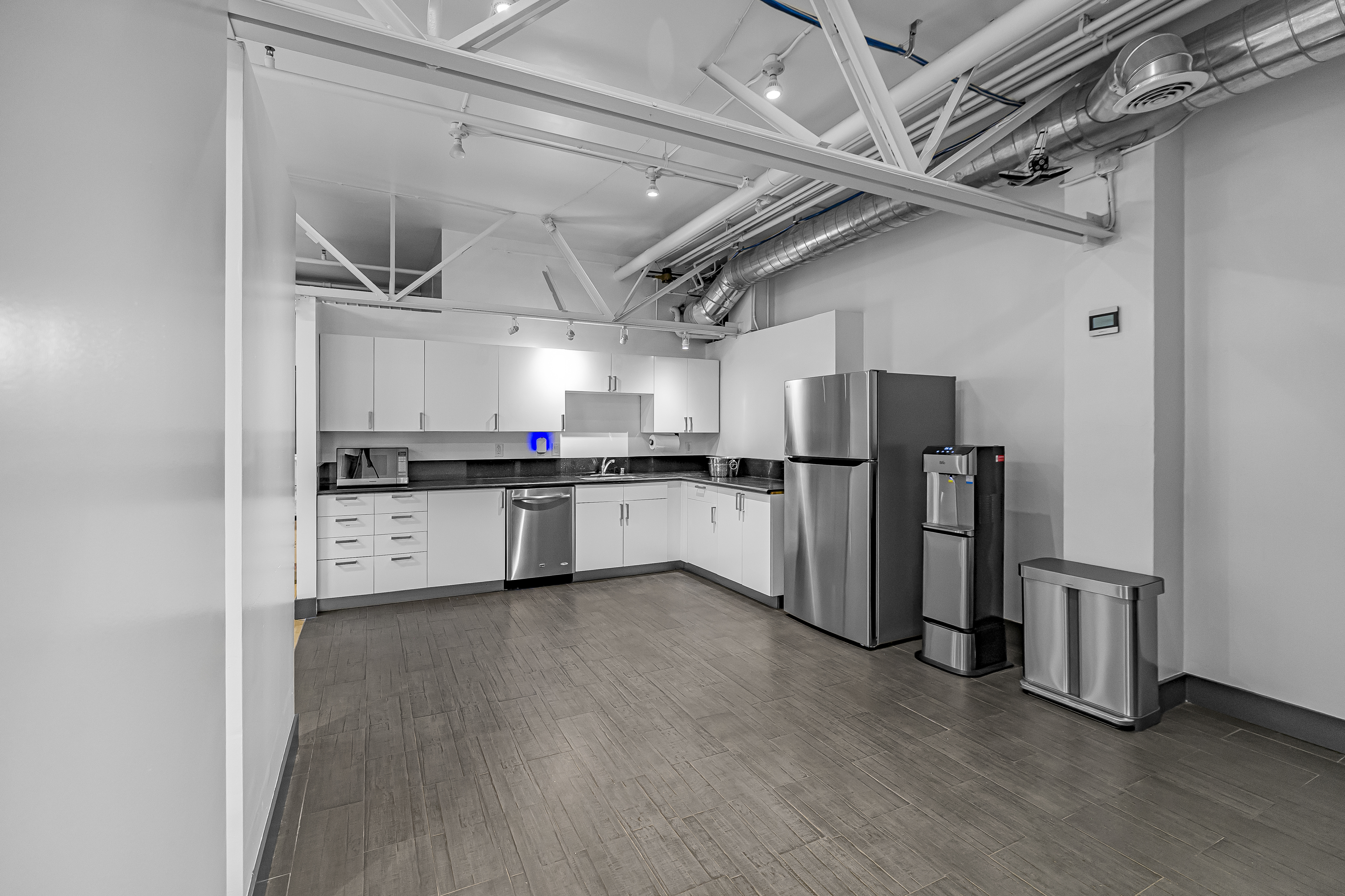 Bright kitchenette with white cabinets, microwave, and counter space