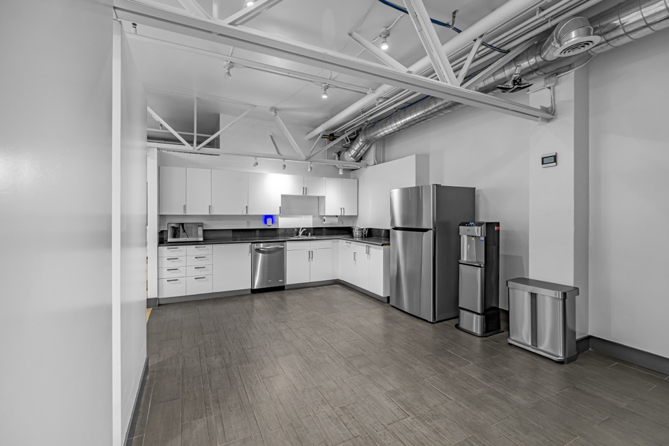 Bright kitchenette with white cabinets, microwave, and counter space
