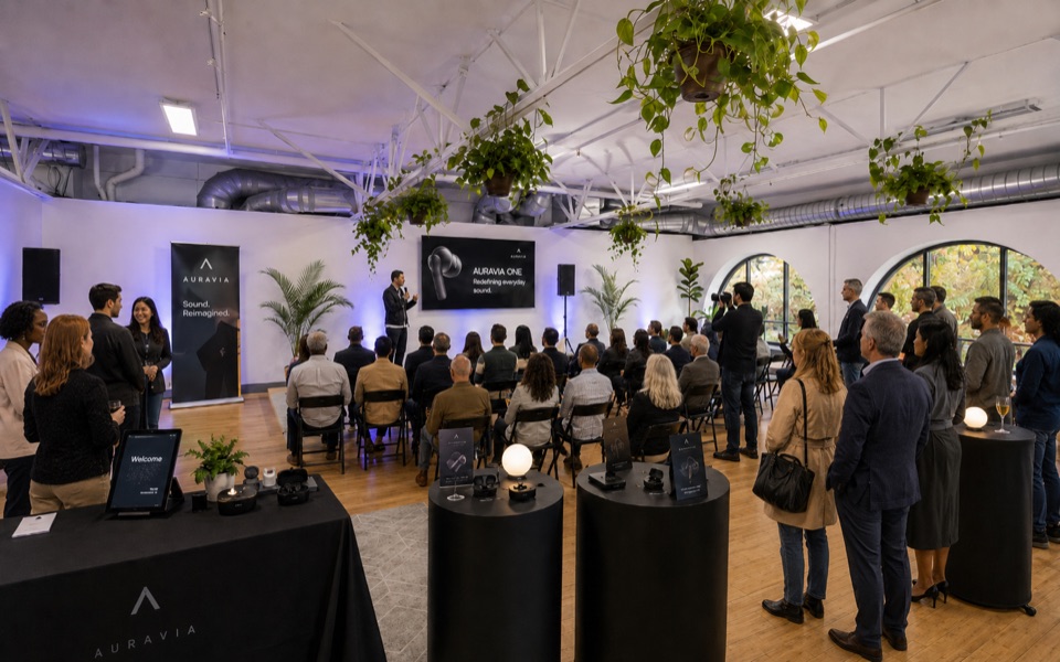 A presenter speaking to a seated crowd at a product launch event in the loft